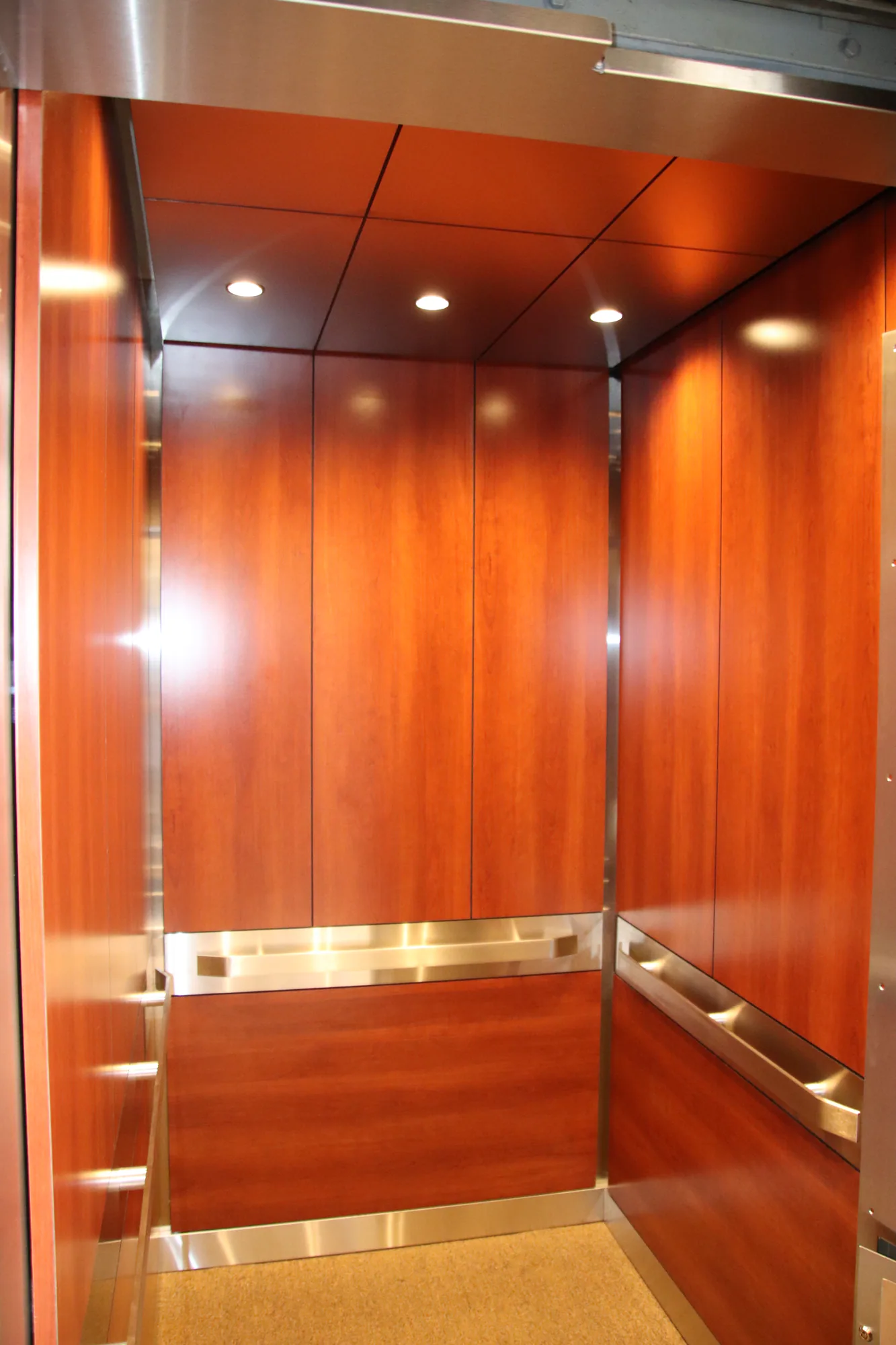 Wood-paneled Chicago bank elevator interior with polished metal rails and warm ceiling lighting