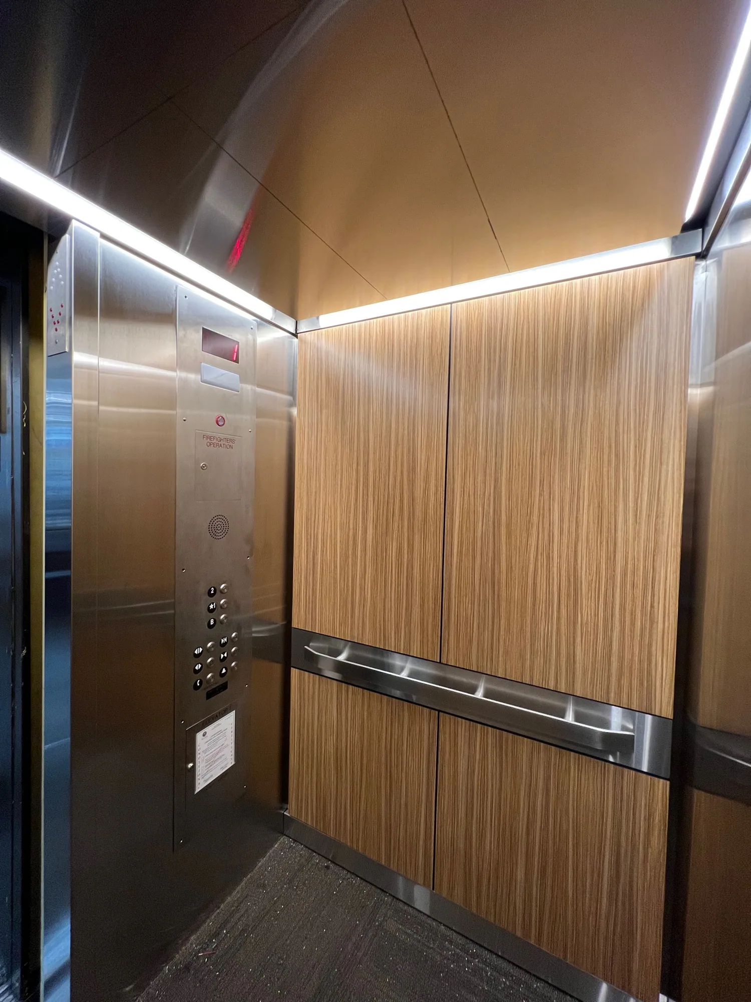 Austin Library elevator cab in Chicago with woodgrain panels and stainless steel rails